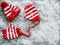 Snow covered small red and white stripped hat with mittens