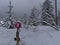 Snow-covered snowshoe hiking path with footprints and trail marking in winter landscape in Black Forest.