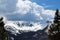 A snow covered summit with pine covered mountainsides at a scenic overlook on the Trail Ridge Road in Rocky Mountain National Park