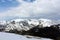 A snow covered summit with pine covered mountainsides at a scenic overlook on the Trail Ridge Road in Rocky Mountain National Park