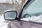 Snow covered SUV side mirror closeup. Cars in winter