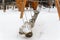 A snow-covered swing in the old style in the form of a log suspended from chains.