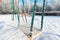 Snow covered swing and slide at playground in