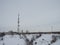 Snow-covered winding road leads to the radio tower with cellular phone in winter, near the village in the north of the Arctic