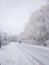 Snow-covered winter road, birches in hoarfrost, winter landscape, soft focus