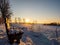 Snow-covered wooden bench in Vogtland during a romantic sunset