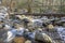 Snow covers a footlog and a small stream in the Great Smoky Mountains.