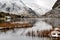 Snow dusted Glyder mountains rising into the clouds reflected in Llyn Ogwen