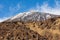 Snow-dusted Teide mountain over brown lava, Canary island of Tenerife, Spain
