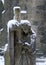 Snow falling an a graveyard staue of a mourning woman