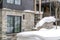 Snow falling on a residential area and a stack of snow at the front