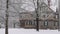 Snow falling in slow motion in front of historic American house in winter