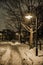 Snow filled city park during the winter at night.