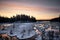 Snow formations on the lake reflecting the colors of the sunset sky