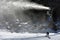 Snow Gun Snowmaker throw snow over a snowboarder in Whakapapa skifield