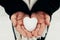 Snow heart snowball in girl gloved hands. Blurred background