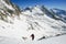 Snow hiker walking on snow with the view of the mountains and blue sky in the background