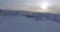 Snow landscape with houses at sea bay lit by sunlight