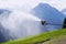 Snow making machines used to water grass on slope, sunny summer day, Wagrain ski resort