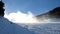 Snow making on slope. Skier near a snow cannon making fresh powder snow. Mountain ski resort in winter calm.