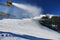 Snow making on slope. Skier near a snow cannon making fresh powder snow. Mountain ski resort in winter calm.