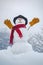 Snow man in winter hat. Christmas background with snowman. Funny snowman in stylish hat and scarf on snowy field. Happy