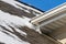 Snow and melting ice buildup on roof of house in winter