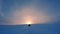 Snow mobile drive fast to the large low Sun in frosty cold foggy winter sky above mountain top in Norway. Drift snow