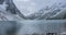Snow mountain lake timelapse at the autumn time. Wild nature and rural mount valley. Green forest of pine trees and