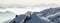 Snow Mountains Panorama in low lying inversion valley fog. Silhouettes of foggy Mountains. Scenic snowy winter landscape