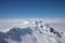 Snow peaks over clouds. Caucasus rocks. White mountains and blue sky.