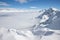 Snow peaks over clouds. Caucasus rocks. White mountains and blue sky.