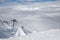 Snow peaks over clouds. Caucasus rocks. White mountains and blue sky.