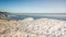 Snow pile, hill. Large snow drift  on a blue sky background,  outdoor view of ice blocks at frozen finland lake in winter