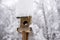 Snow piled high on a wooden bird box