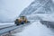 Snow ploughing truck cleaning snow on the road in suburban during heavy snowstorm