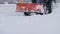 Snow plow tractor cleans road from snow in the winter