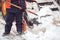 Snow removal in the city. Worker helps shovel snowplow