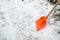 Snow removal. Orange Shovel in snow.