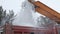 Snow removal on the streets. Close-up of falling snowballs from a snowplow and into a truck body. Municipal urban road maintenance