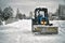 Snow removal in winter village using a tractor