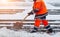 Snow removal. Worker clearing snow by shovel after snowfall. Outdoors