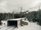 Snow shed on train railway surrounded by alpine trees during winter