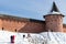 snow slope of riverbank near wall of Monastery