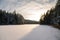 The snow on the snow-covered, forested Lake Melnezers, in the rays of the evening sun, Latvia