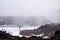 Snow storm building up over ski field on the slopes of Mt Ruapehu. Ski lifts go above beginner skiers and melting snow