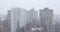 Snow storm with high winds blowing snowflakes sideways, against tall apartment buildings in the back, in Bucharest, Romania