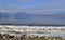 Snow strip at lake shore with mountains in background