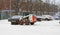 Snow tractor removes snow during snowfall and blizzards in parking lot in Katajanokka. Helsinki, Finland