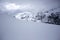 Snow Valley in the mountain range in Chile Country Among clouds of mist and mist emerges the rocky mountain peak